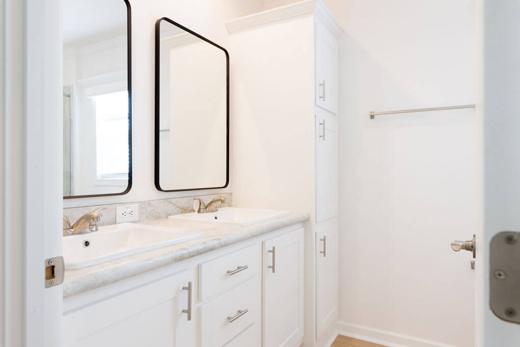 A bathroom with a double vanity inside amanufactured home in Jamaica Bay Village. 