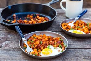 Hash breakfast on a grey plate on a picnic table