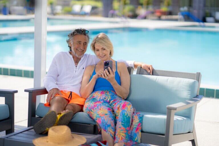 A couple sitting by the swimming pool at Rolling Greens Village in Ocala, Florida.