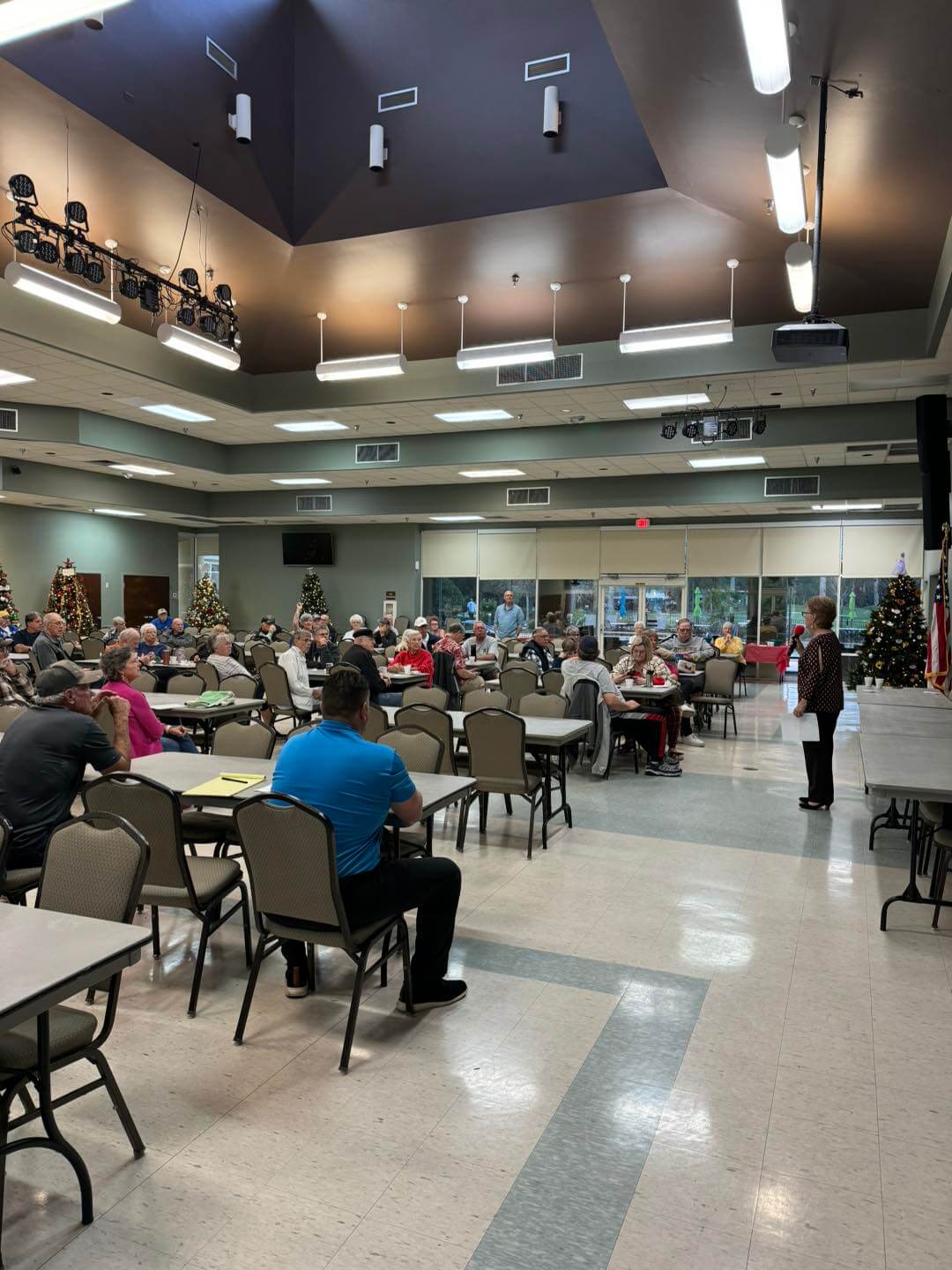 Hands using scissors to cut red felt on a wooden table