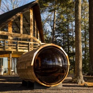 Sauna in front of a lodge with trees surrounding it