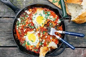 Shakshuka breakfast in a skillet on a picnic table