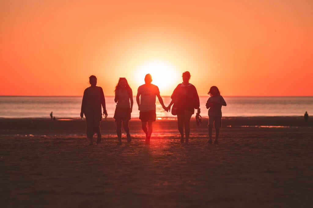 Holding hands on beach at sunset