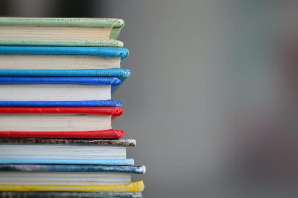 six colorful books, stacked.