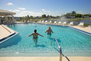 Two people entering a pool