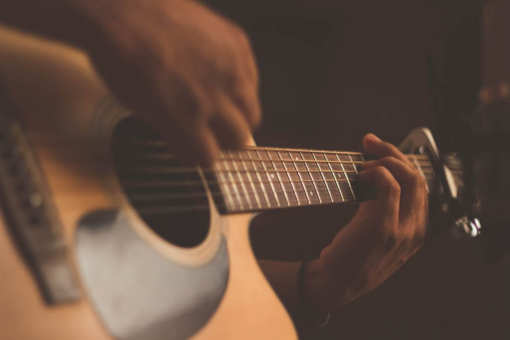 Close up of someone strumming a bass guitar