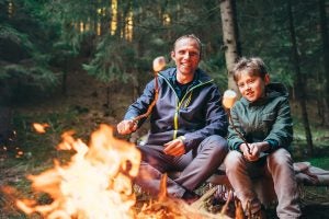 father and son roasting smores