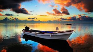 Fishing boat on water at sunset