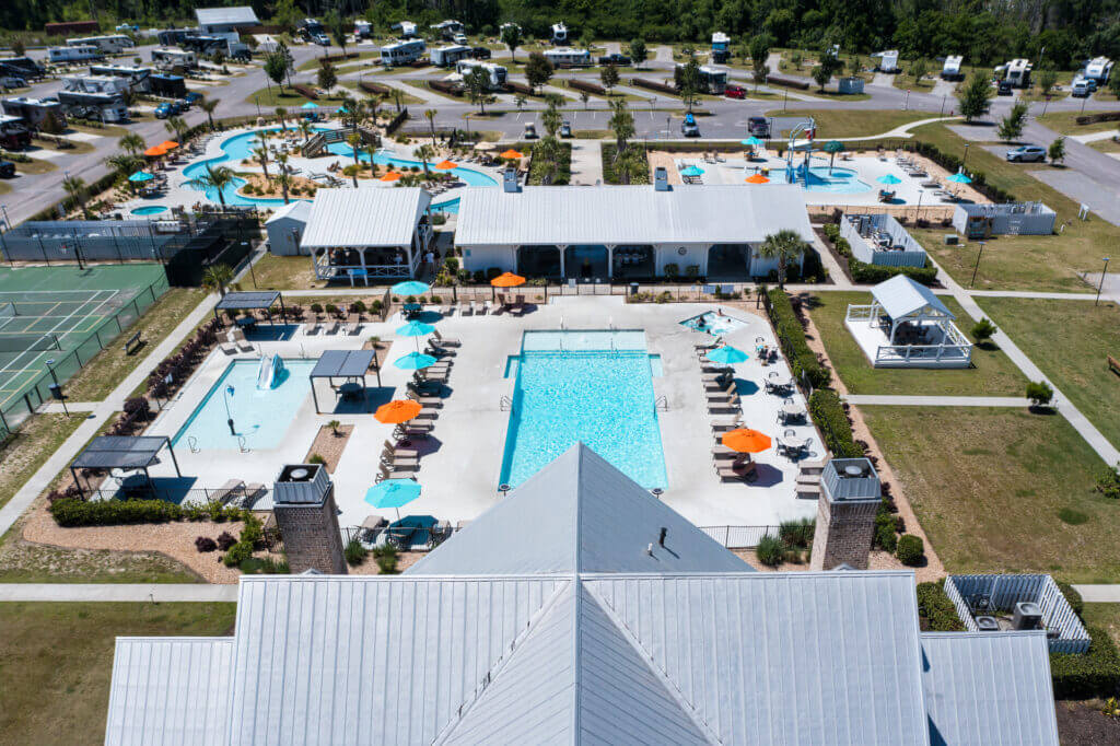 Drone photo looking down at the swimming pools, lazy river, and splash pad at CreekFire RV Resort.