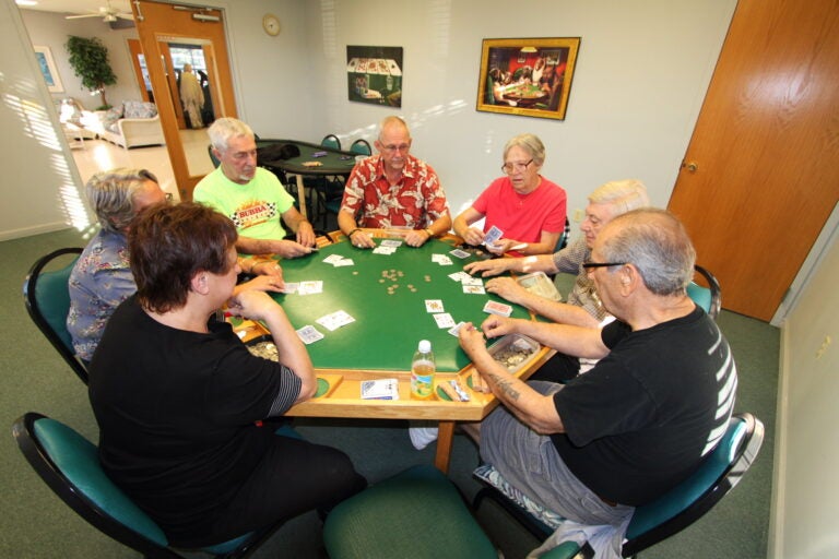 men and women playing poker at table