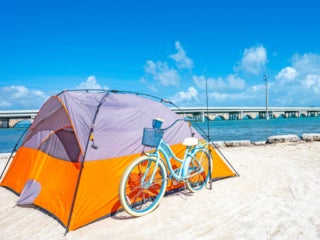 Orange tent and a turquoise bicycle sitting along the beach at Big Pine Key RV Park in Florida