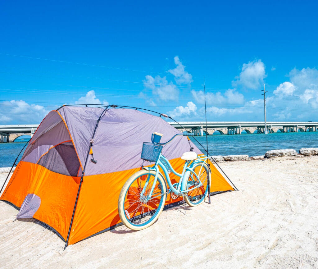 Orange tent and a turquoise bicycle sitting along the beach at Big Pine Key RV Park in Florida