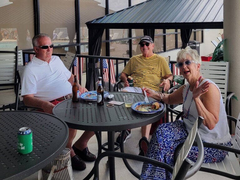 Residents sit around a table at Red White & Blue Wine Wednesday in Camelot East Village in Sarasota, Florida.