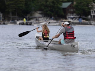 Daughter and dad canoeing on Sebago Lake off the shores of Point Sebago Resort in Maine.