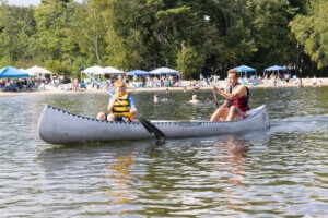 Father and son canoeing on Sebago Lake off the shores of Point Sebago Resort in Maine.
