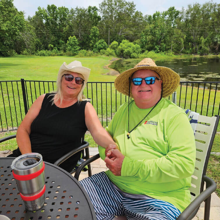 Couple sitting on the patio outside at Holiday RV Park in Leesburg, Florida.