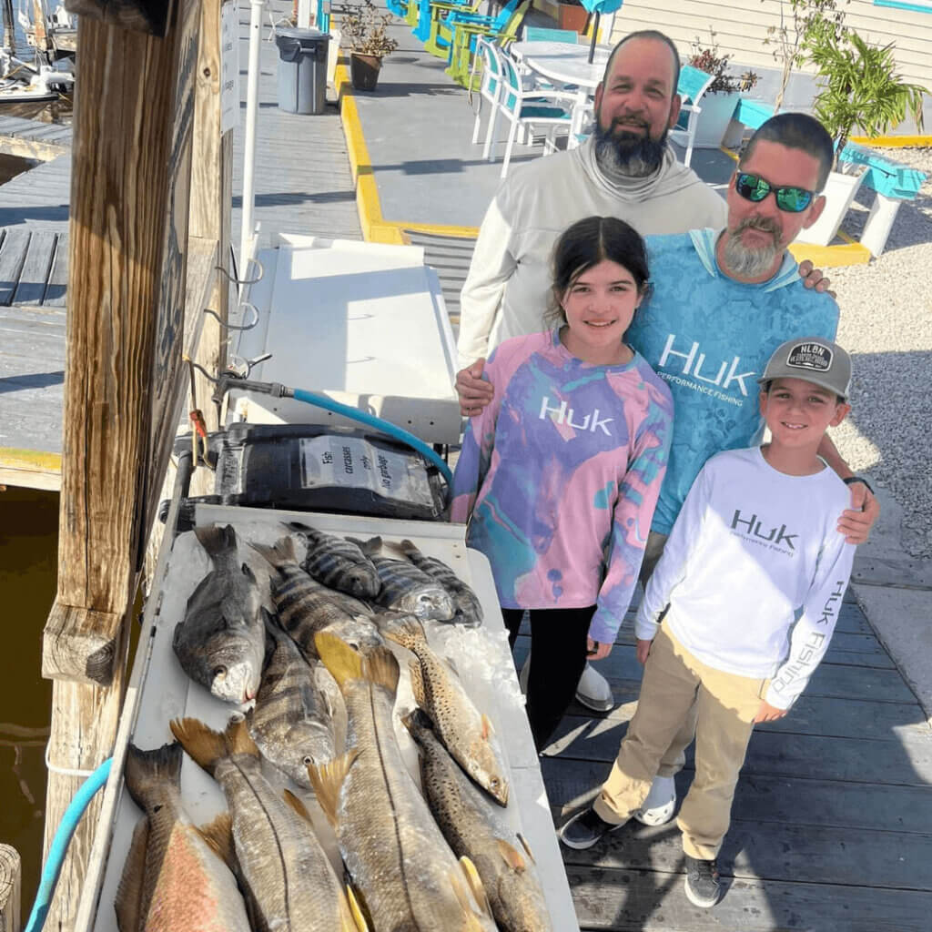 Fishing_Family_Chokoloskee Two kids and two adults showing off their fishing catch at Chokolsokee RV Park in Florida.