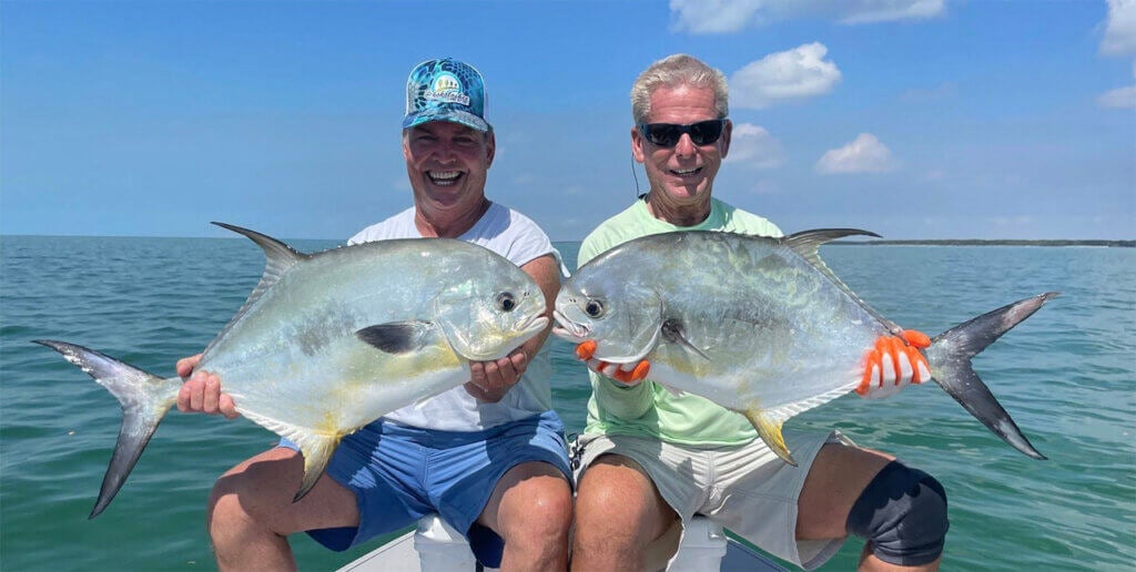 Two men posing with fish they caught off the coast of Chokoloskee Island in Florida.
