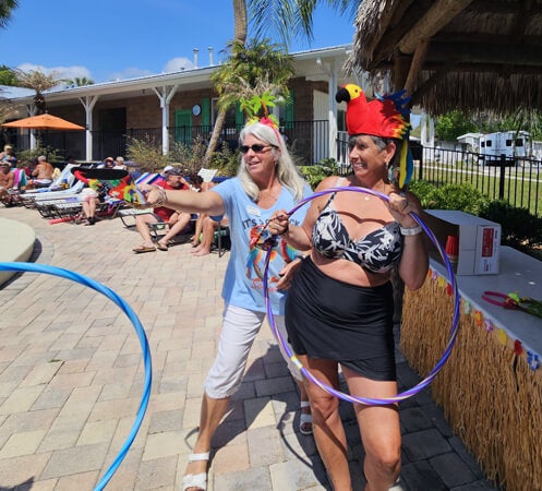 Guests playing games by the outdoor pool at 55+ Holiday RV Park in Leesburg, FL