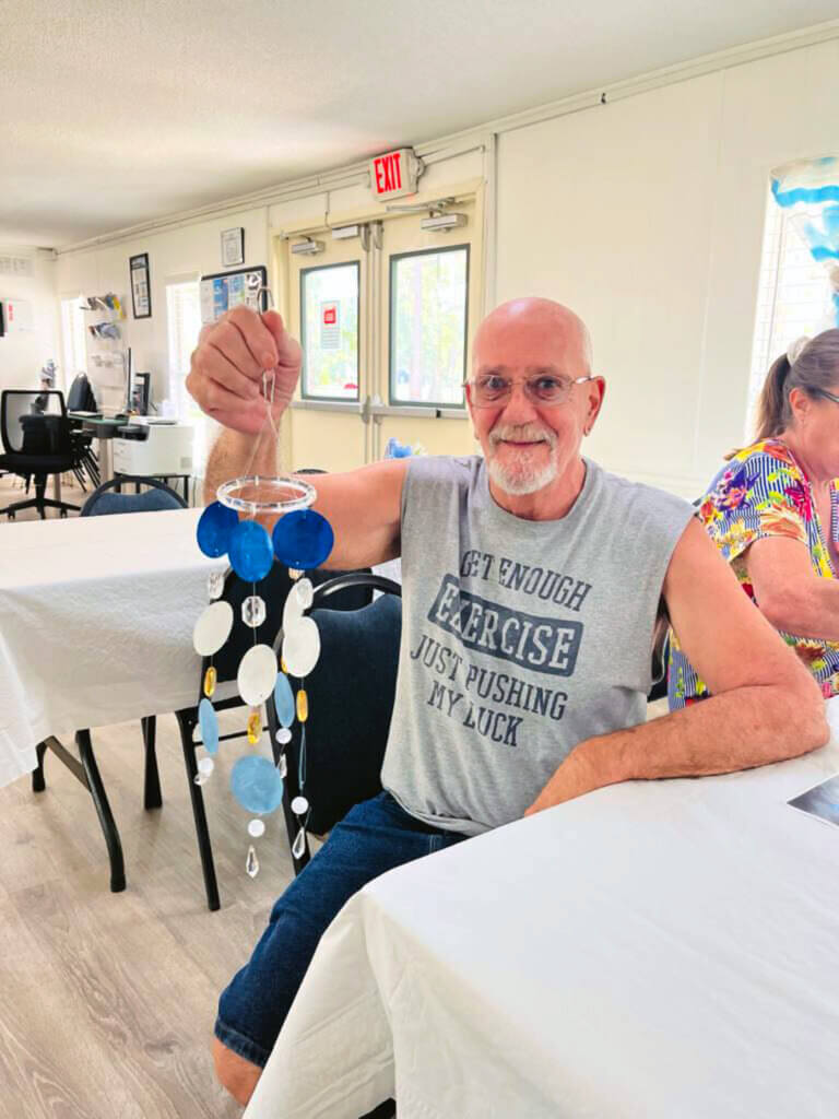 Resident holds craft from craft night at Meadowlea Village in DeLand, Florida.
