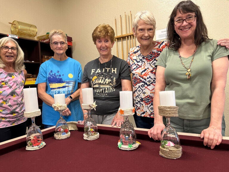 Five residents of The Meadows in Tarpon Springs, Florida showing off their candle holder crafts.