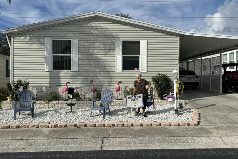 A woman showing off the manufactured home in Tarpon Springs, Florida after winning "Yard of the Month" at The Meadows.