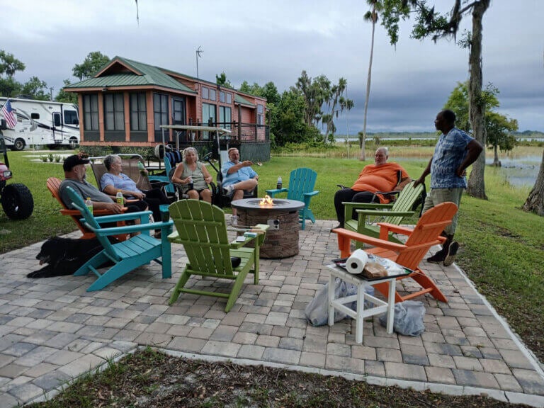 Group of friends sitting around the fire pit at Oak Harbor RV Park in Florida.