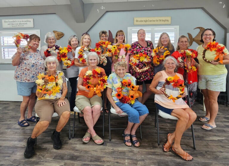 Women who live at Holiday RV Park show off their handcrafted October wreathes.