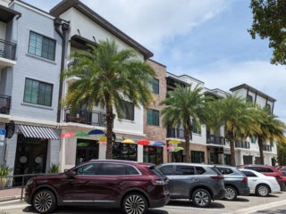 Shops along a row of parked cars in DunedIn, Florida.