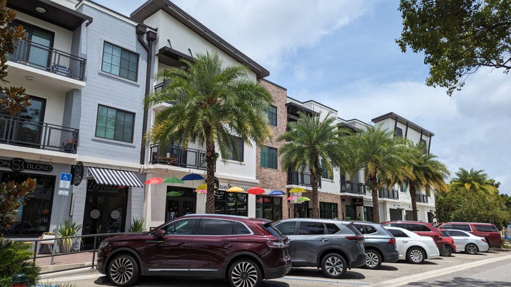 Shops along a row of parked cars