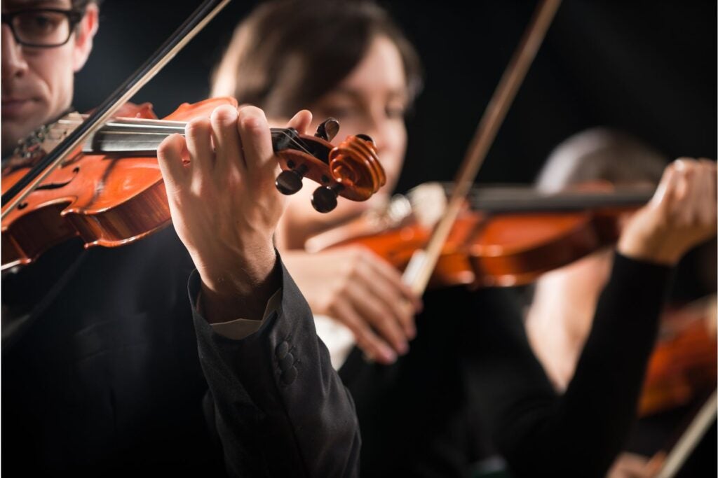 Two people playing violins