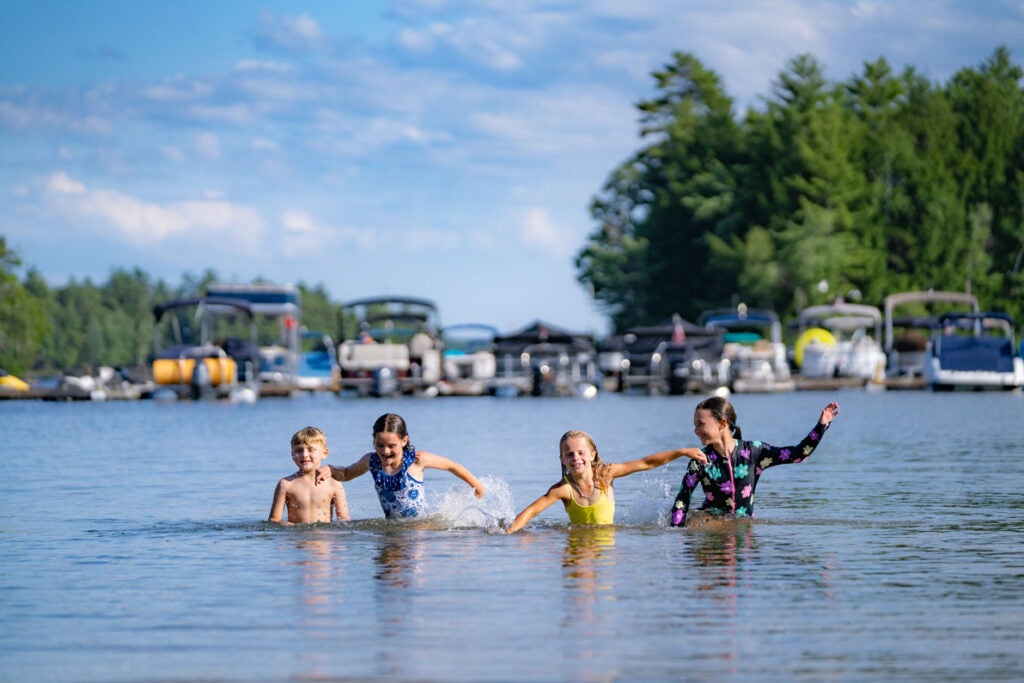 Kids swimming in Sebago Lake at Point Sebago Resort in Maine.