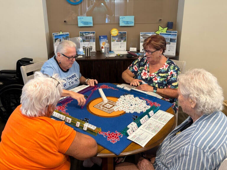 Four friends playing mahjong at Rolling Greens Village in Ocala, Florida.