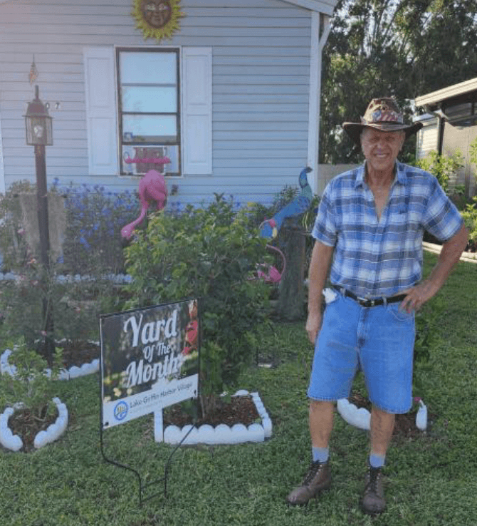 Man standing in front of his yard at Lake Griffin Village in Leesburg, Florida.