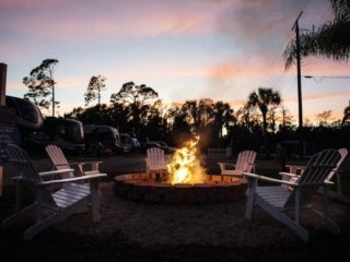 Firepit surrounded by chairs at dusk in Blueway RV Park.
