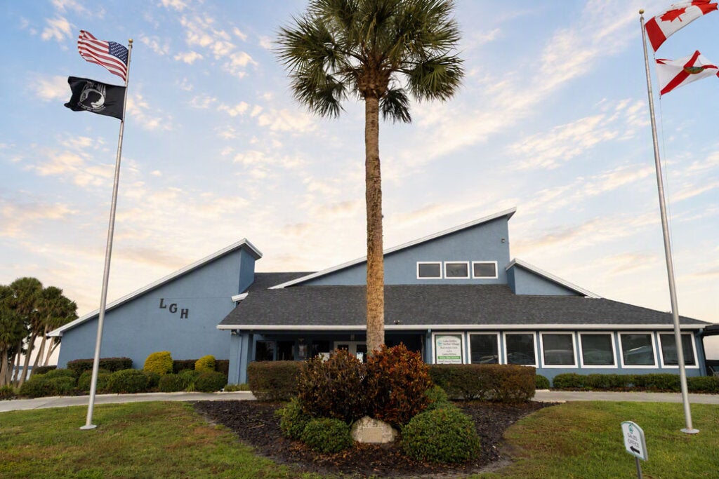 The clubhouse with flagpoles outside at Lake Griffin Harbor Village in Leesburg, Florida.