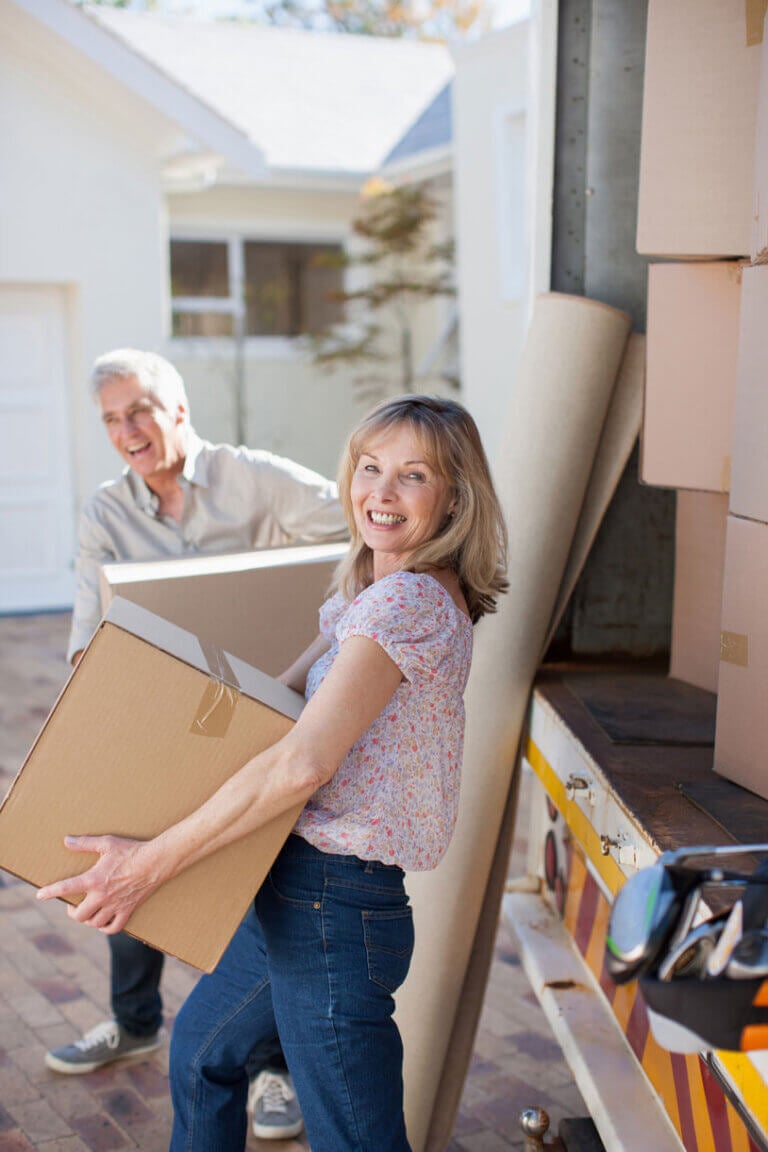 Couple carrying boxes from moving van