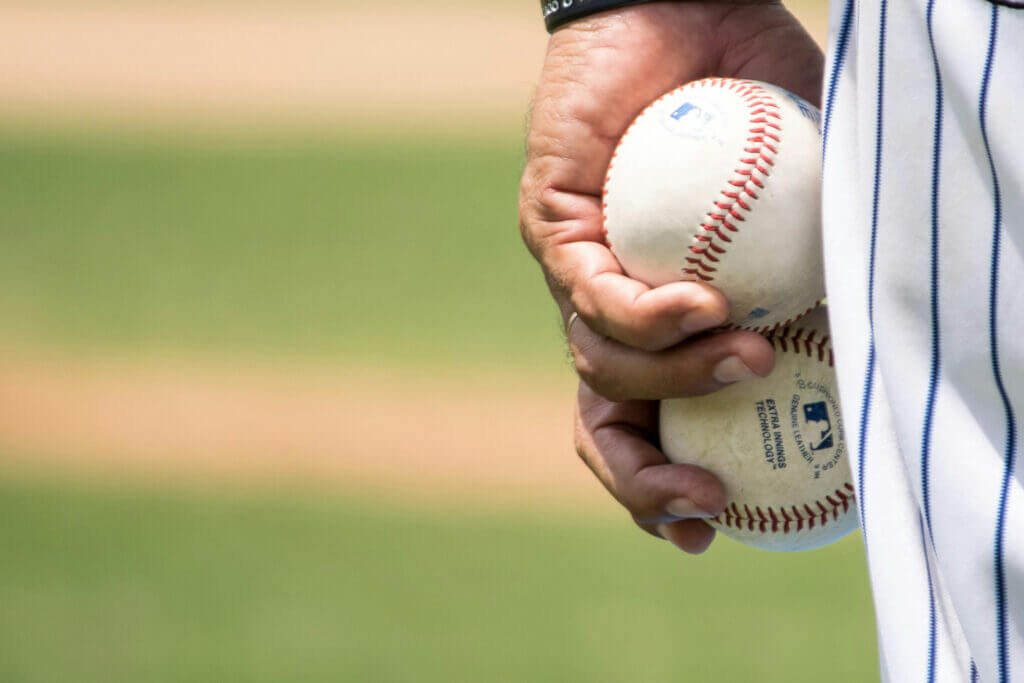 hand holding to baseballs