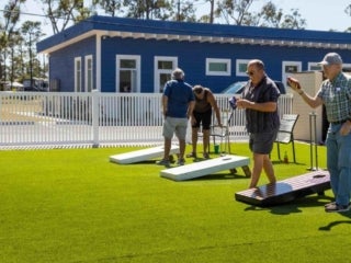 Four people photographed playing cornhole at River Vista RV Park.