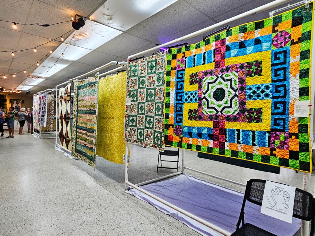 Beautiful and intricate quilts are hung in the Holiday RV Park Quilt Show hosted in the Activity center.