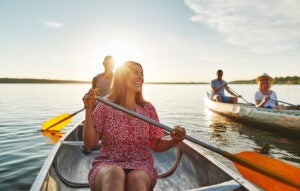 Laughing woman canoeing with friends on a late summer afternoon