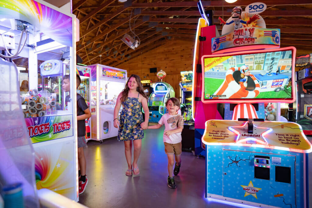 Two kids walking through the arcade at Point Sebago Resort in Casco, Maine.