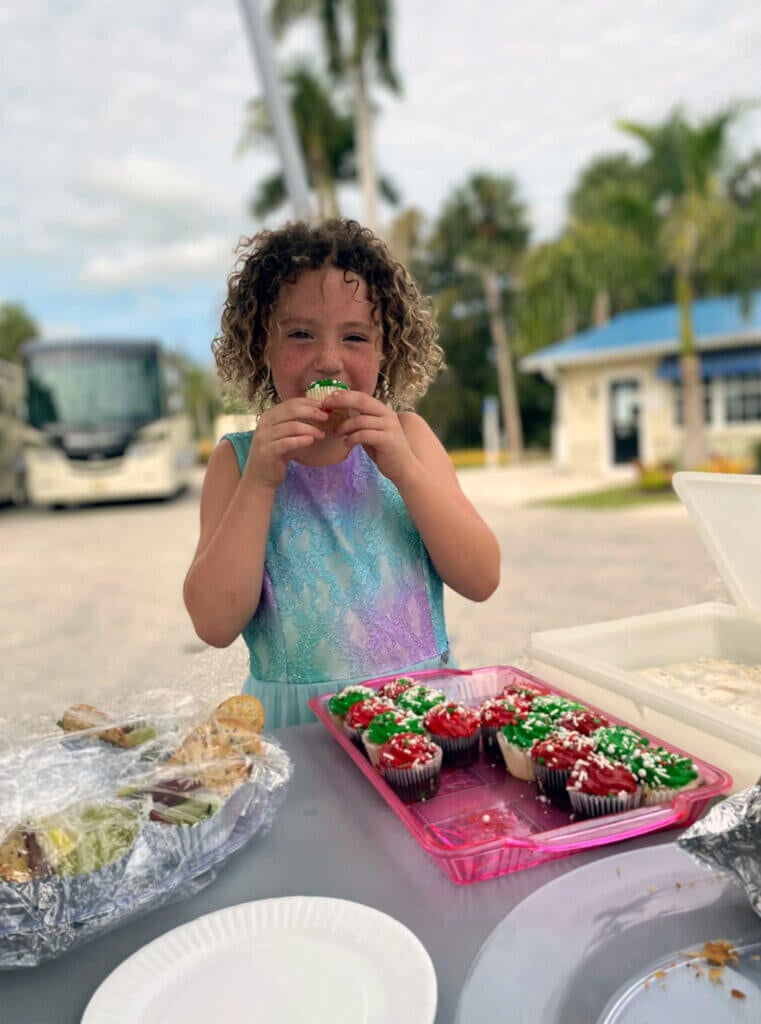 Girl eating Christmas cupcake at Blueway RV holiday potluck