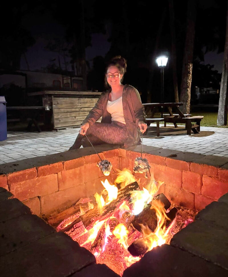 Guest roasting marshmallows in the firepit at Blueway RV Park in Fort Myers, FL.