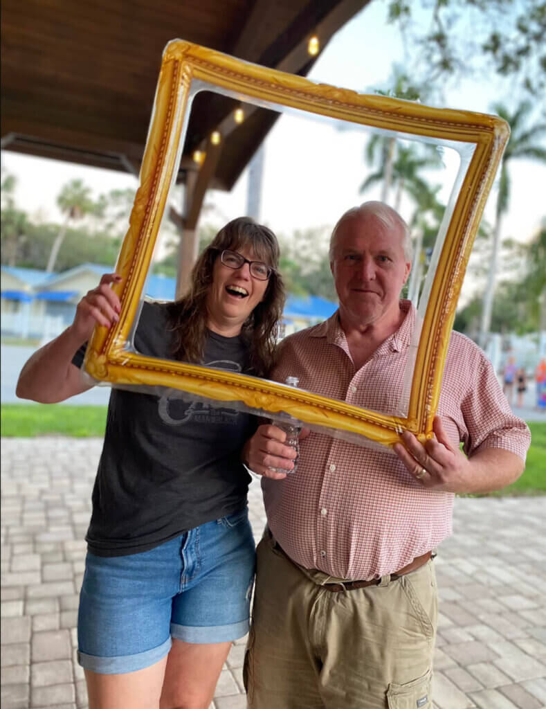 Guests hold a picture frame for a photo op at the thanksgiving potluck