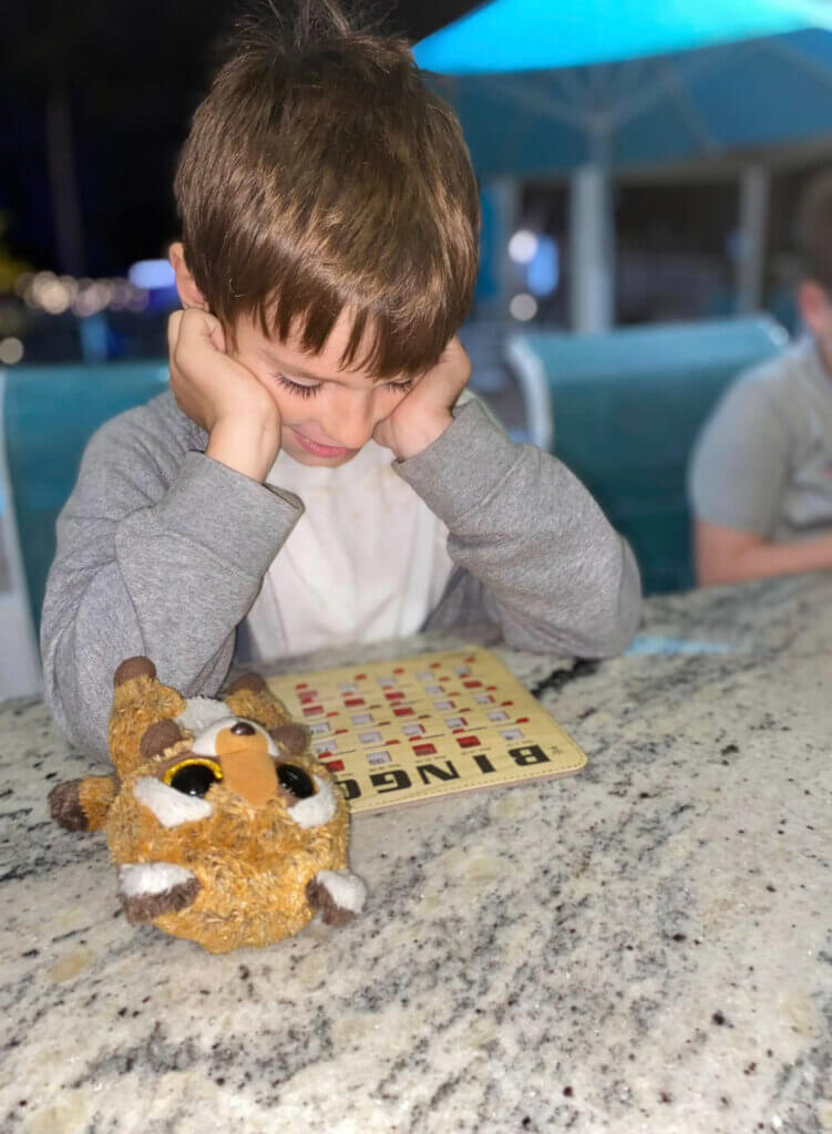 Young boy at Blueway playing bingo with his reindeer stuffed animal