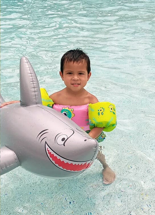 Young boy with shark pool float in the Blueway RV Park swimming pool in Fort Myers, FL.