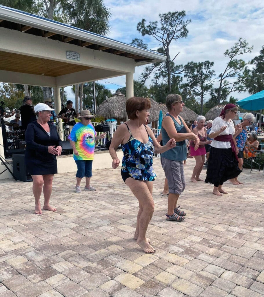 Guests dancing to live music on the pool deck at Blueway RV