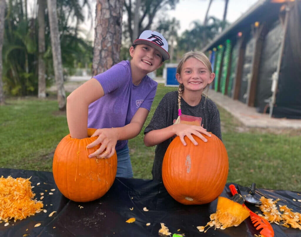 Two girls at Blueway carving pumpkins