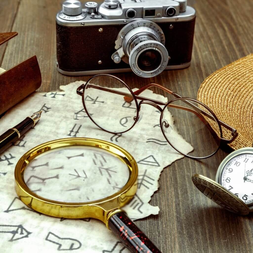 Magnifying glass, camera glasses, and stopwatch on a map for a scavenger hunt.